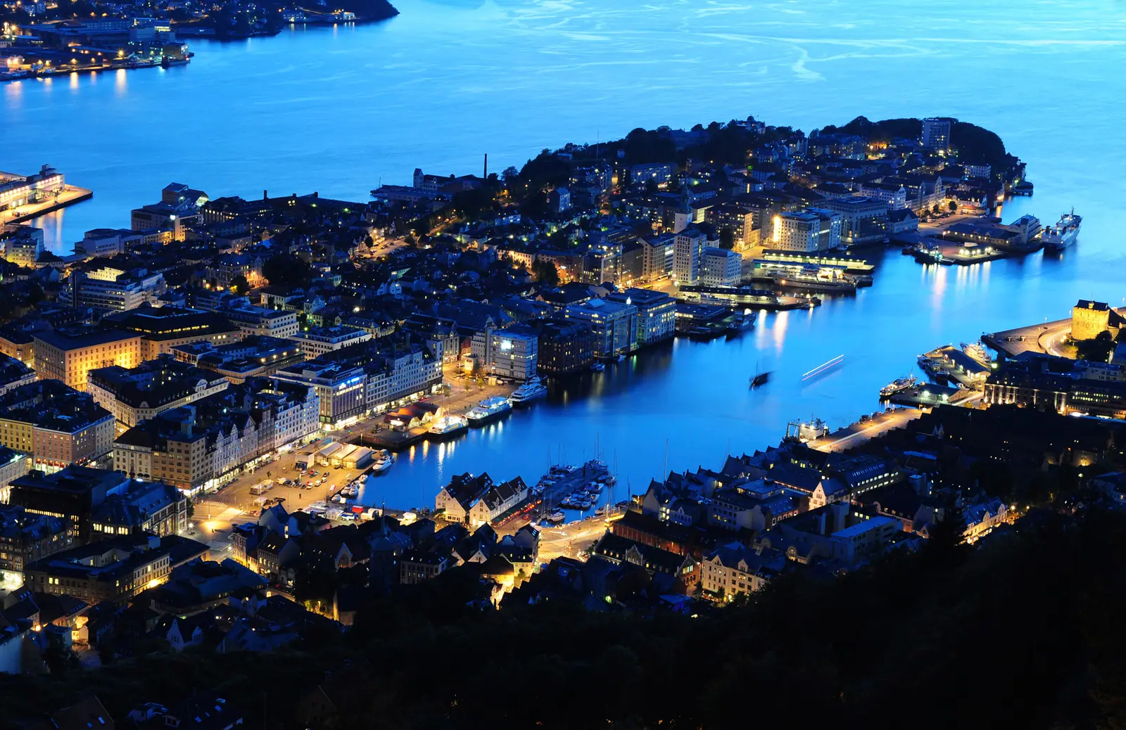 Bergen sentrum og Vågen i blåtimen, sett fra Fløyen — lysene er tent i byen